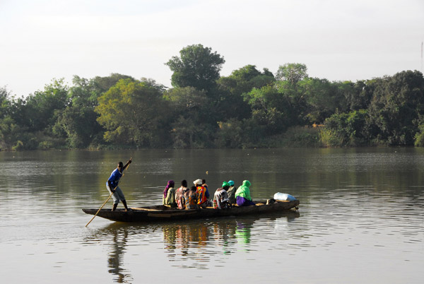 Pirogue ferryman (Nomory Sow from Babaroto, Mali) poles his way across the Bakoy