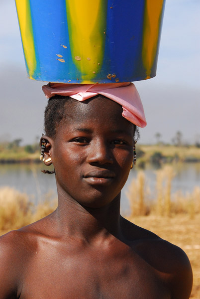 Young mother carrying a bucket, Dilia