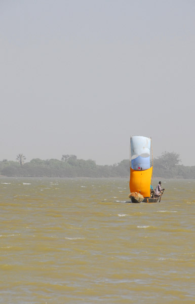 A double sailed pirogue heads upriver