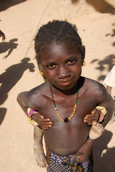 Young girl with a baby clinging to her back