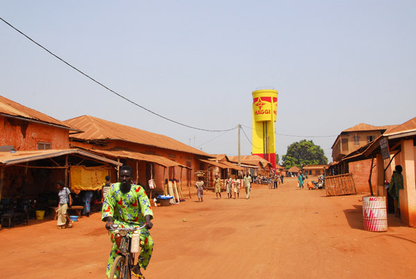 Cyclist on a wide dirt road in downtown Abomey