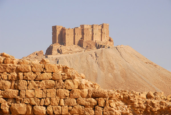 The Arab Citadel rising behind ruins of the defensive wall of Diocletian's Camp, Palmyra