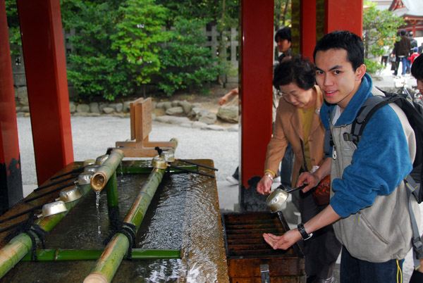 Tan, from Chiang Mai, Thailand, washing his hands at the shrine