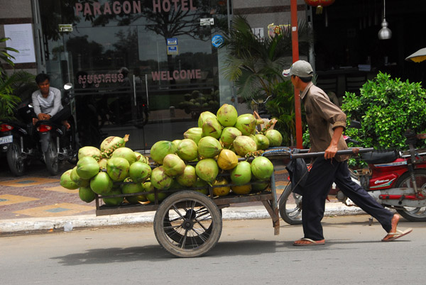 Man pushing a cart of coconuts, Phnom Penh