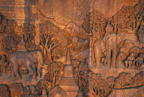 Woodcarving of elephants by a temple on a mountain