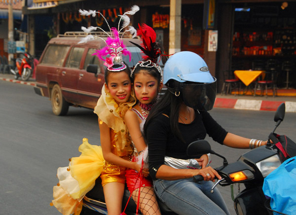 Two girls in costume on the back of a motorbike, Chiang Mai