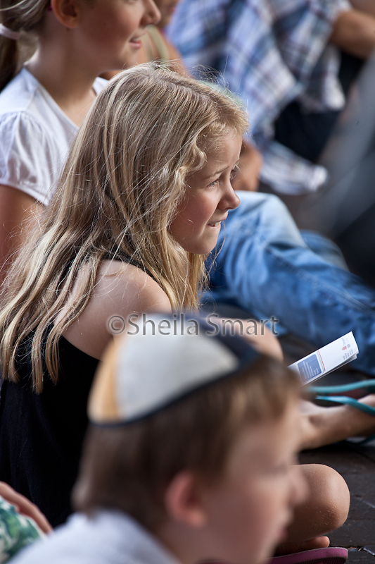 Little girl in crowd watching busker