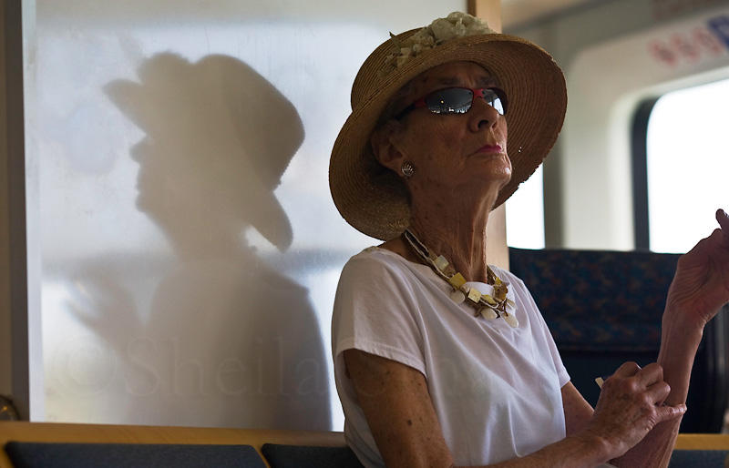 Lady on ferry in hat with reflection