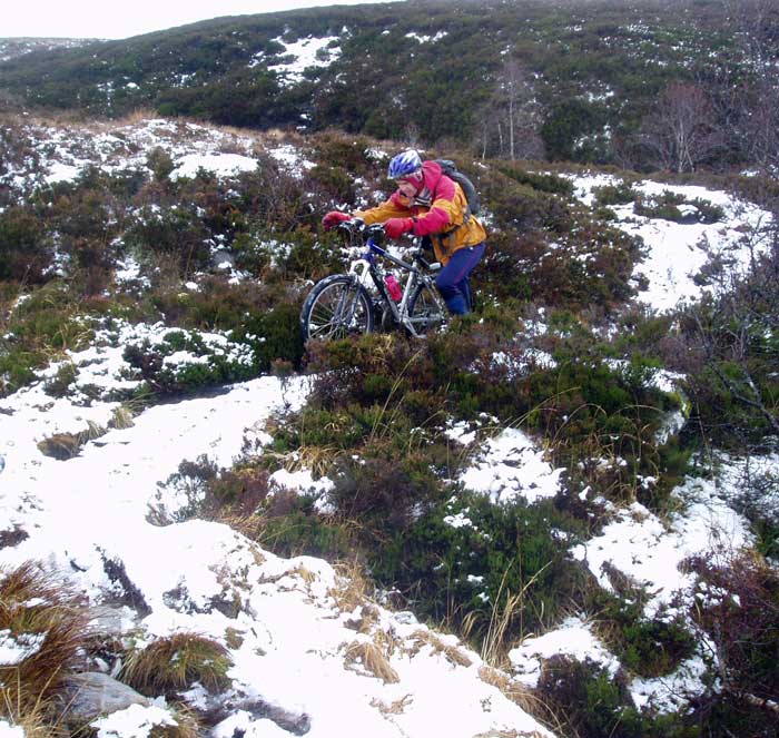 Dec 07 2 day Cairngorms mountain bike trip - Brian pushing through snow in Glen Feshie