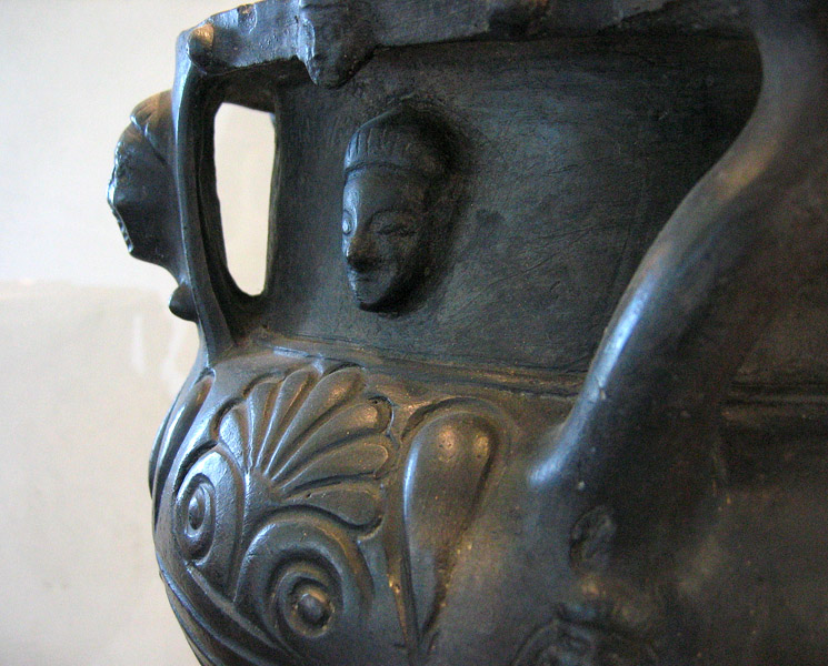 Serene Etruscan face, Asian appearance, on vessel in glass case