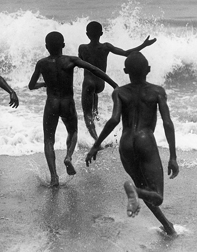 Boys running into the surf at Lake Tanganyika, ca. 1930