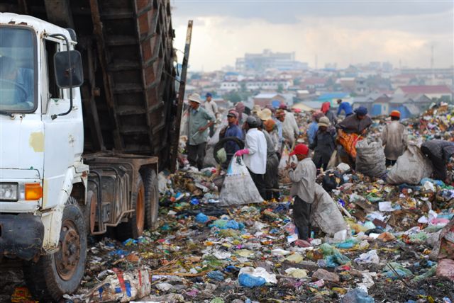 A truck drops off some fresh garbage.