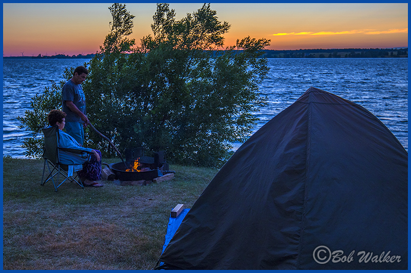 Campers Roasting Marshmallows At Sunset  