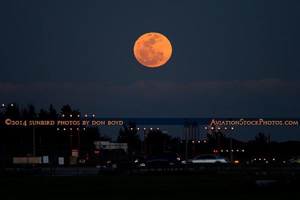 2014 - a large full moon rising on Valentines Day over the approach lights for runway 9L at Opa-locka Executive Airport
