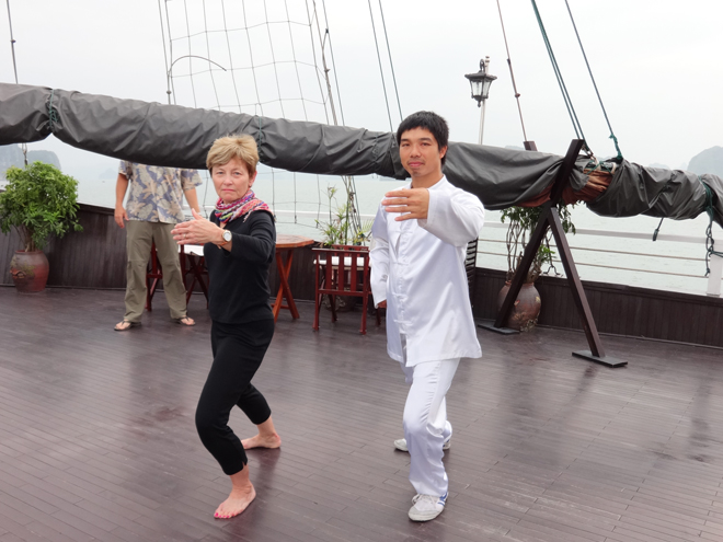 Janet learning Tai Chi aboard the Treasure Junk in Ha Long Bay, Vietnam