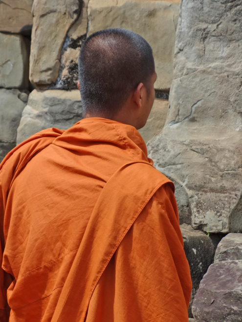  A Hindu monk at a wall of the 9th century c.e. Bakong Temple - in the Roluos Group, Cambodia
