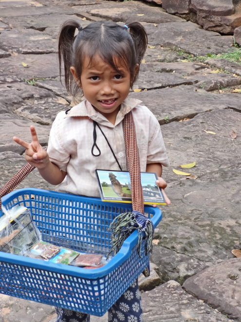 Cute little girl selling souvenirs while we were walking on a road to Preah Khan, Angkor, Siem Reap, Cambodia