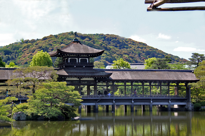 Roofed bridge (Taihei-kaku) over a pond at the garden of the Heian-jingu Shrine in Kyoto (background - Higashiyama Hills)