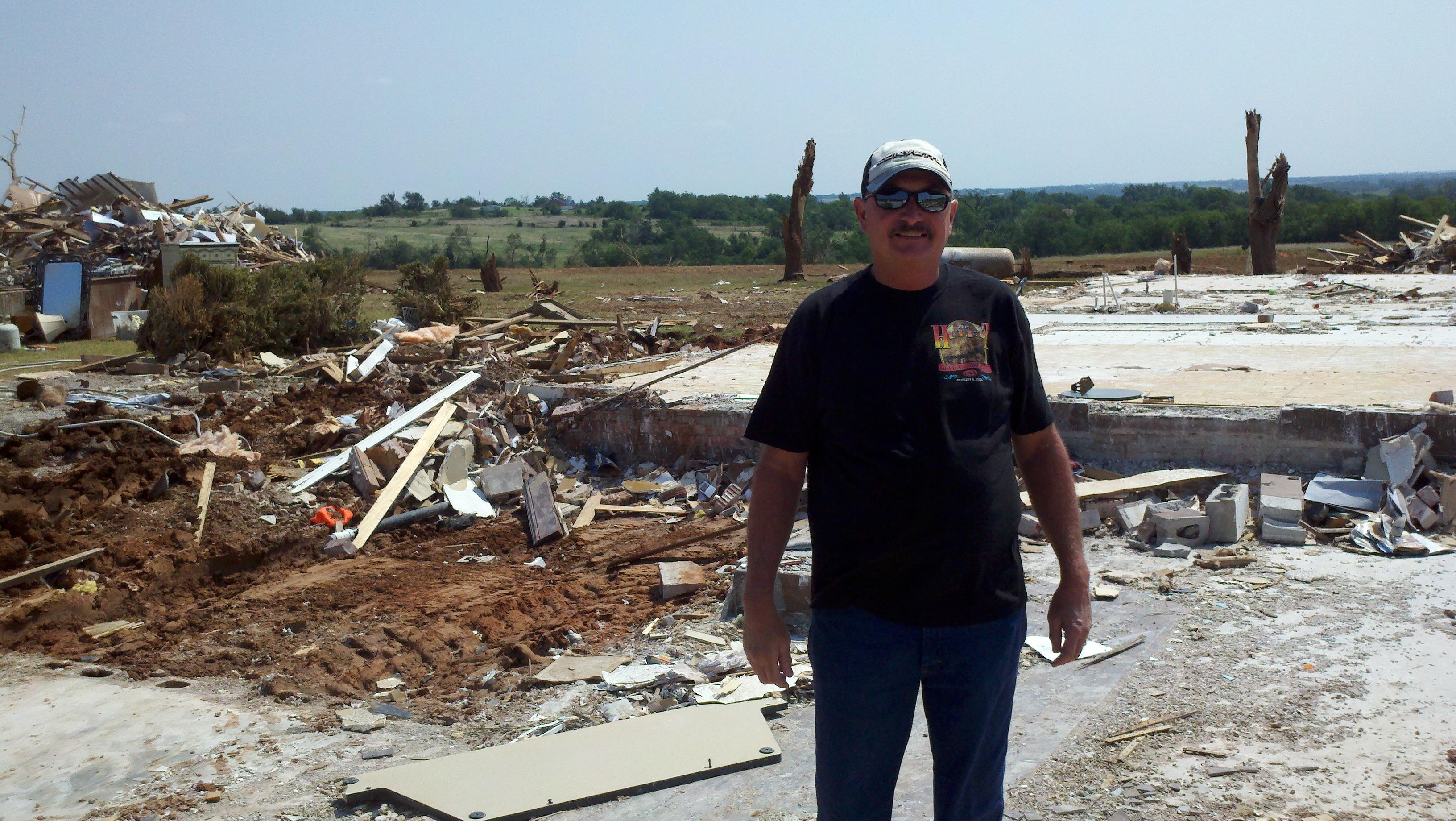 Homeowner Ron Mercer and in the background are the remains of his home where he pushed it from off the foundation