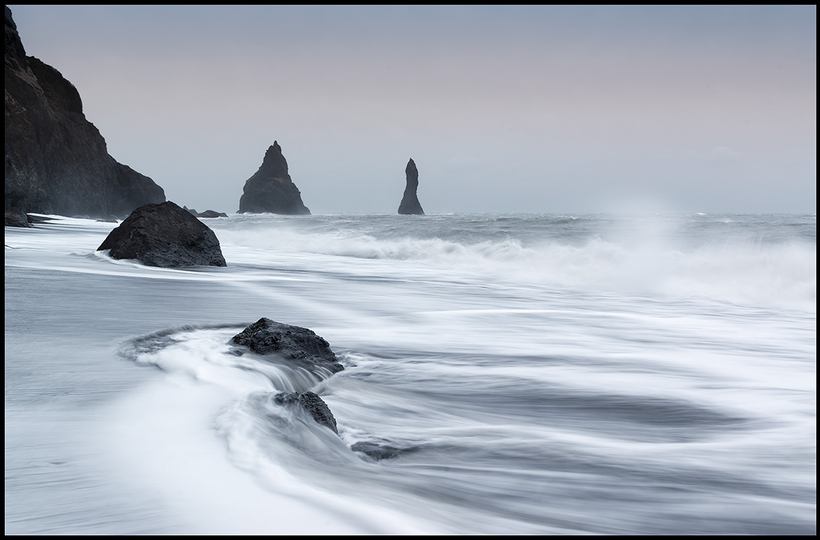 Stormwaves from south-east at Reynisdrangar near Vik with sand drift  over the ocean