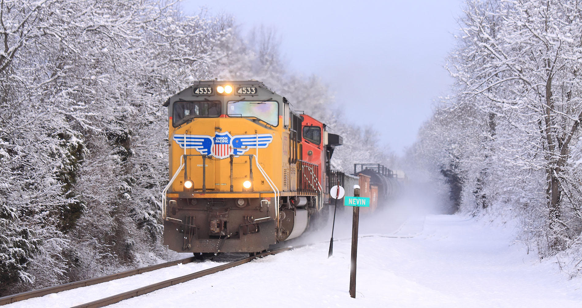 NS M67 comes by Nevin behind a Dirty Bird and a CN unit. 