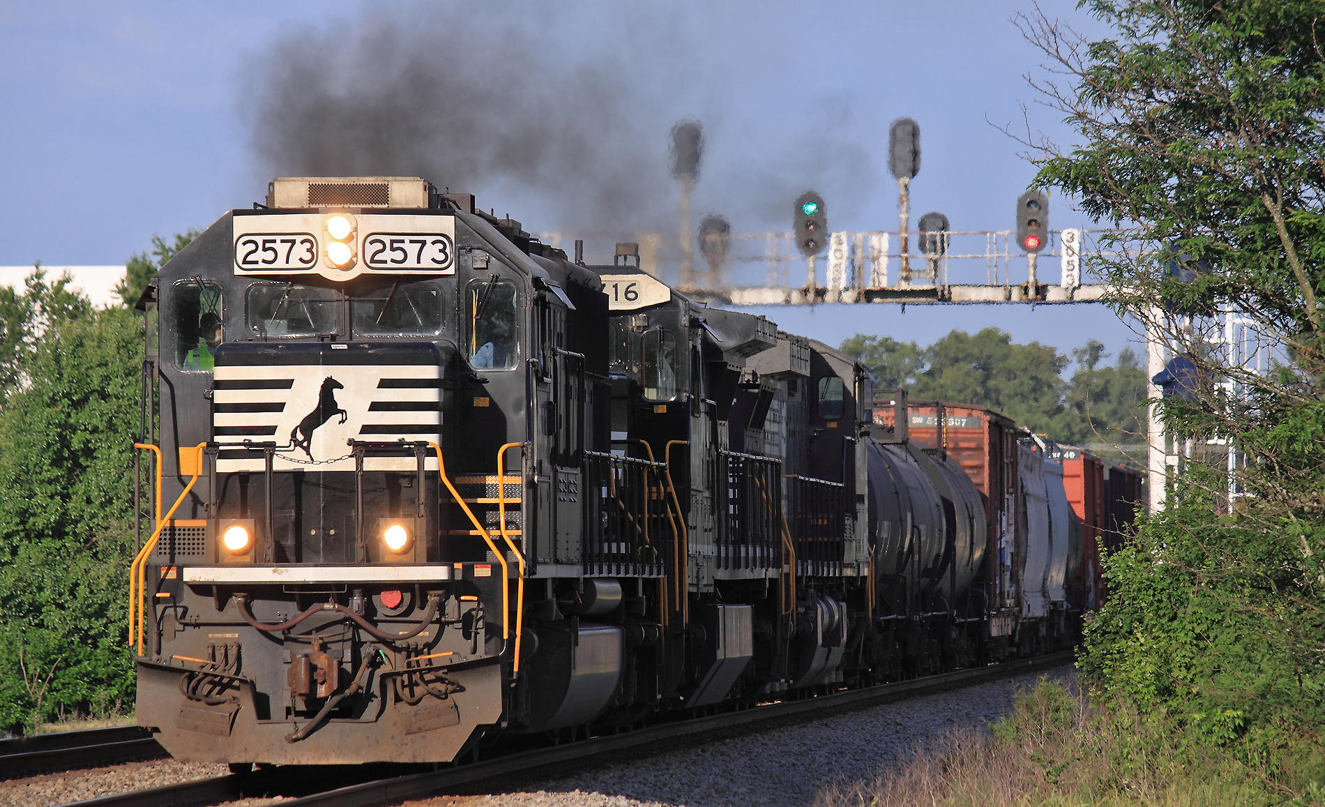 A SD70 leads a Eastbound manifest under the signal bridge at Thomasville 
