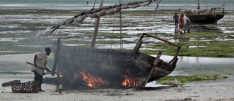 Burning off barnacles (?)  at Nungwi
