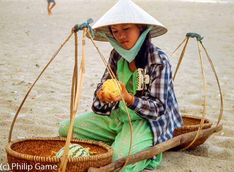 Beach vendor cutting up fruit, Vietnam