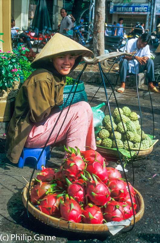 Young woman selling green dragon fruit