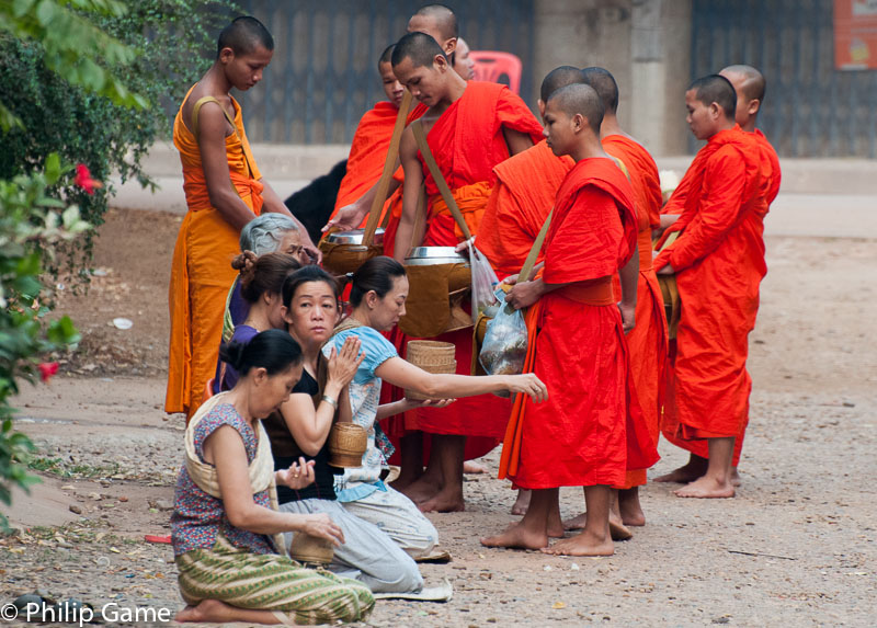 Buddhist monks on their early morning rounds, gathering alms
