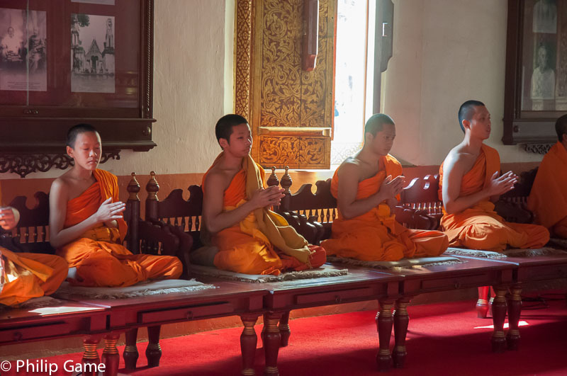 Buddhist monks conduct a ceremony of worship inside Wat Phra Singh