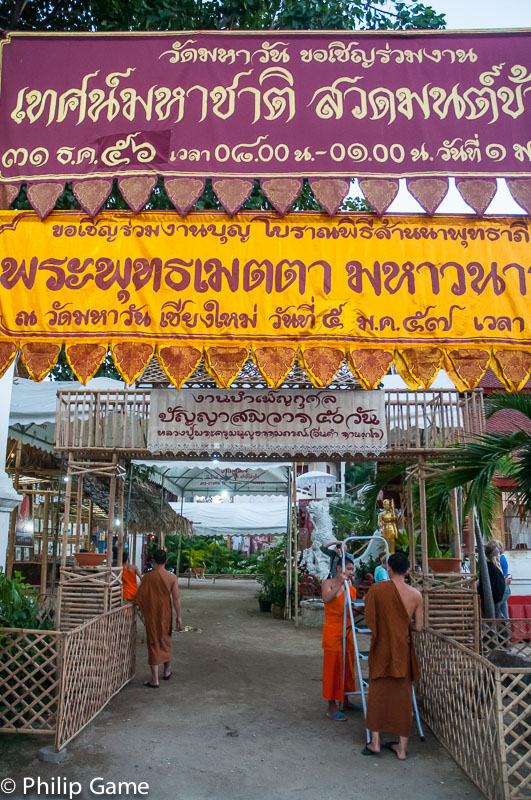 Buddhist monks erect banners in Thai and Shan languages at Wat Mahawan