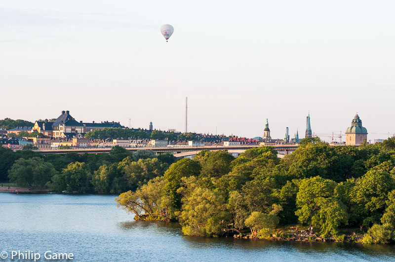 Hot air balloon soaring above Västerbron bridge, with the city centre beyond