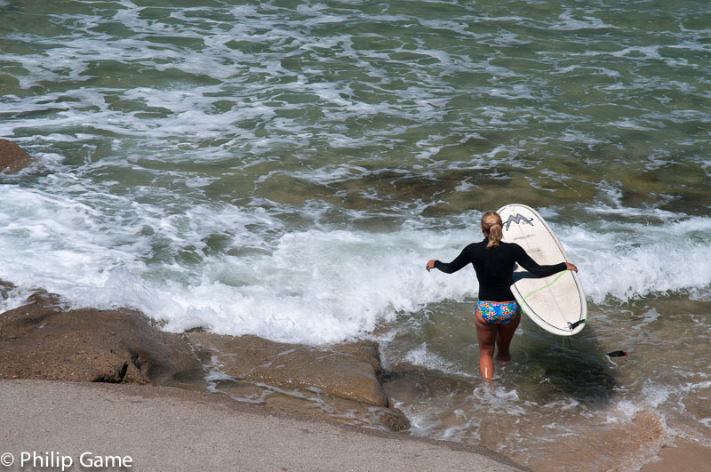 A lone surfer sets forth from Bulcock Beach 