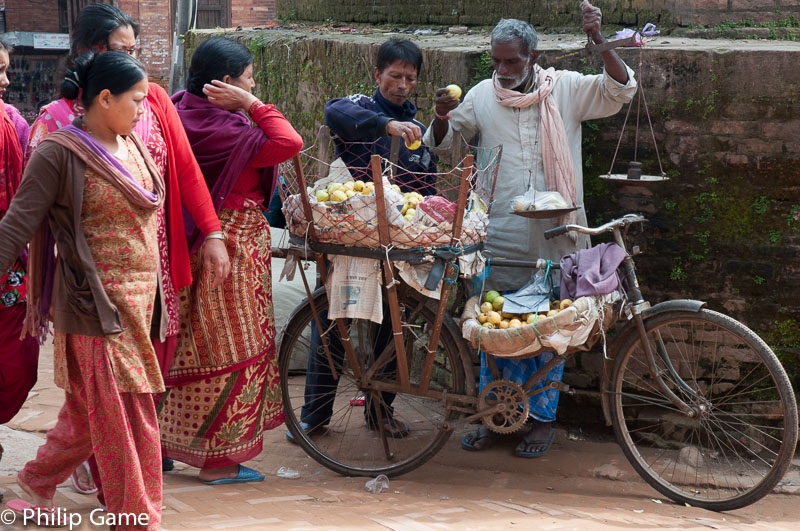Women gather around a peddler's bicycle