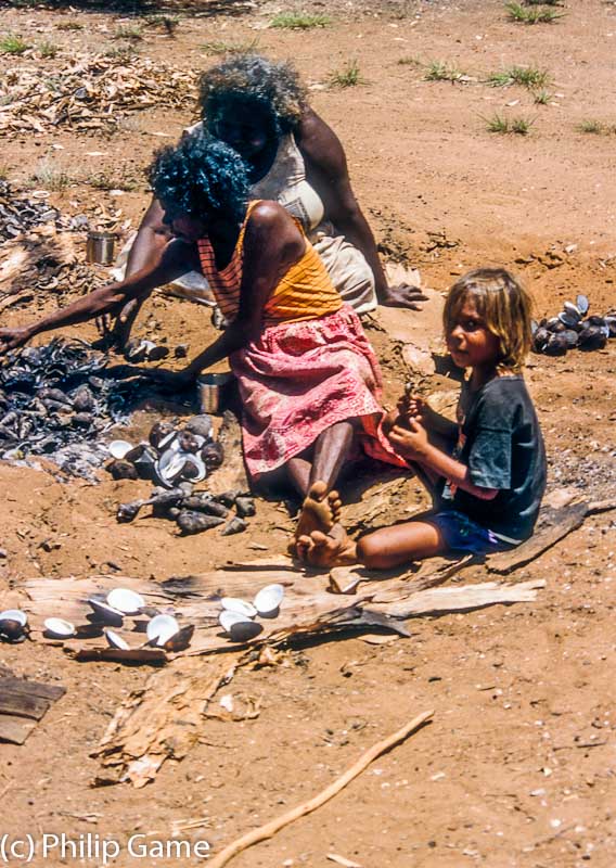 Women and girls cooking whelks