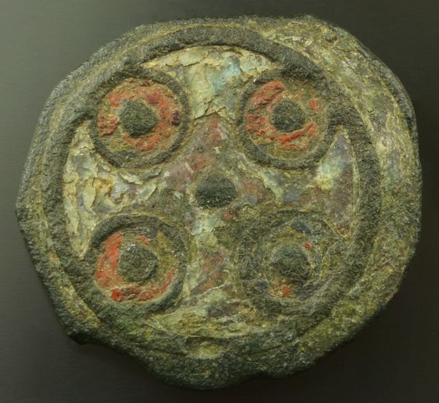 Anglo Saxon enamelled disc brooch in champlev, 9th Century, with a green cross defined by the four red circles. Norfolk.