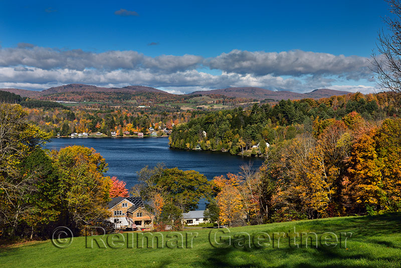 Cottages and houses on Harveys Lake West Barnet Vermont with trees in Fall color