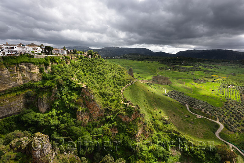 Dappled sunshine on green fields in spring at El tajo gorge at the mountain city of Ronda Spain