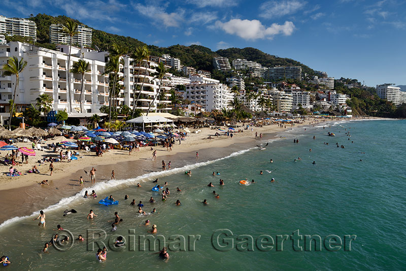 Locals and tourists swimming in the Pacific ocean at Los Muertos beach Puerto Vallarta Mexico