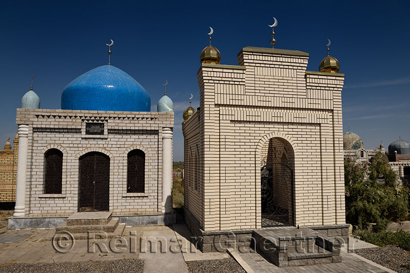 Hilal crescent moon symbols on Muslim brick mausoleums at a cemetery near Shelek Kazakhstan