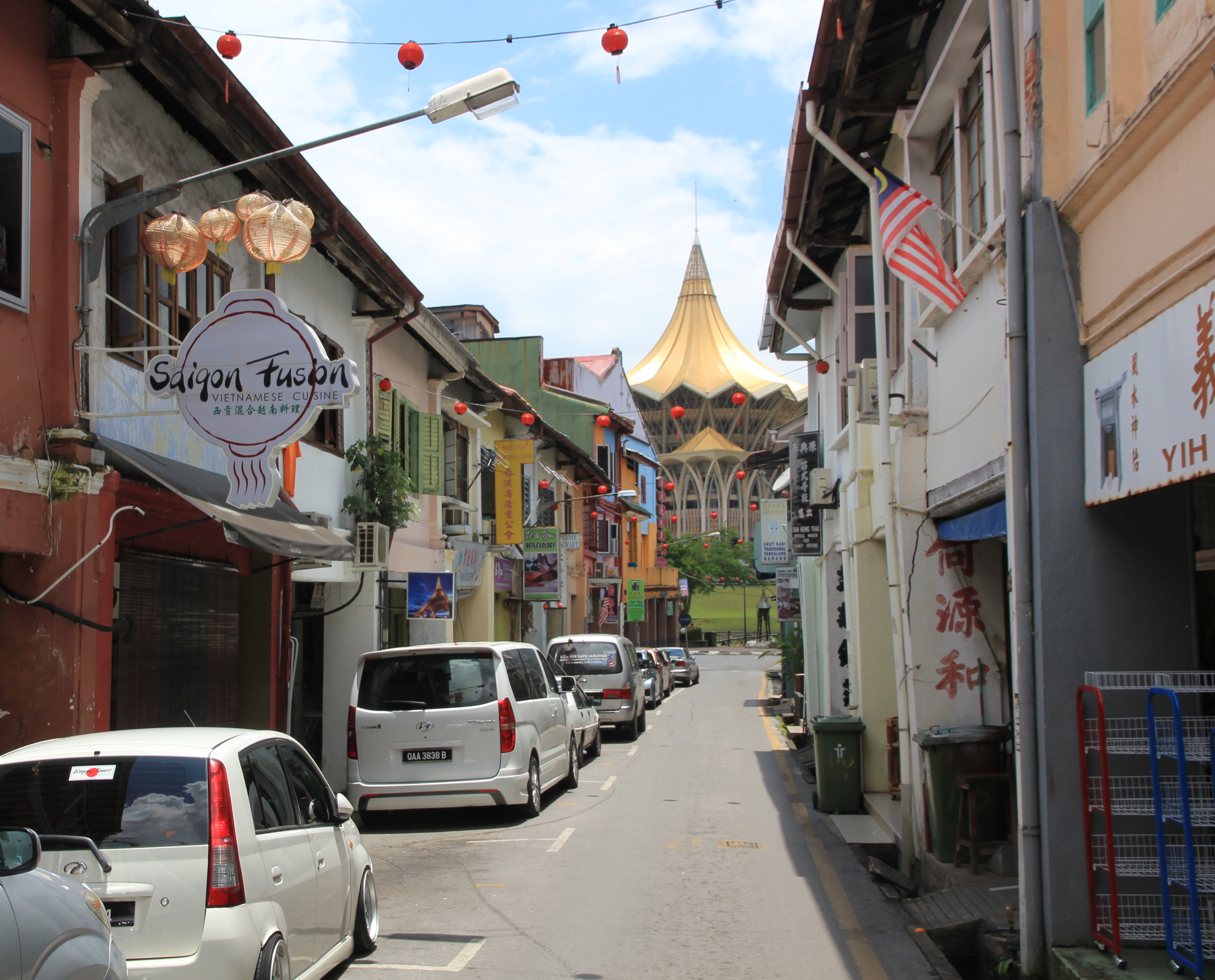 Street in Chinatown. Sarawak State Assembly on the opposite bank of the river in the background