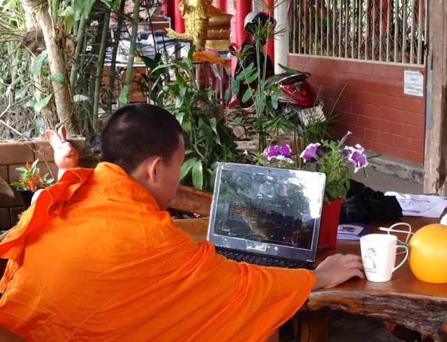 Monk checks sport on computer