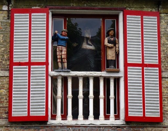 Puppet characters at window overlooking canal