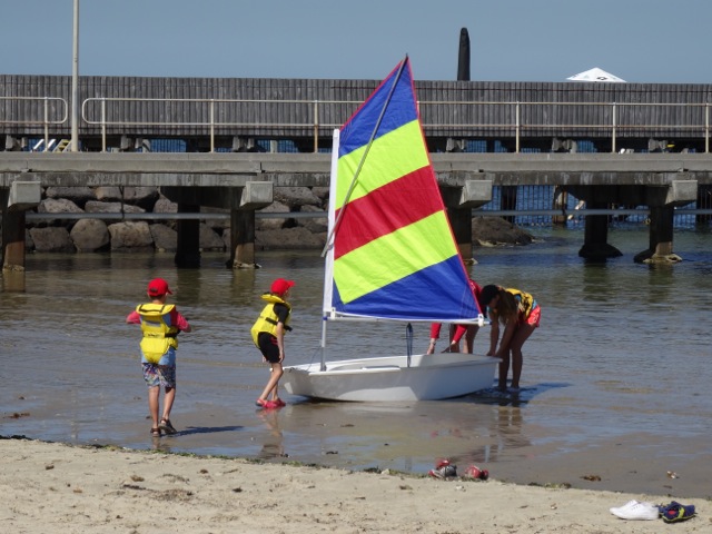 Little sailors launch a boat at Brighton beach