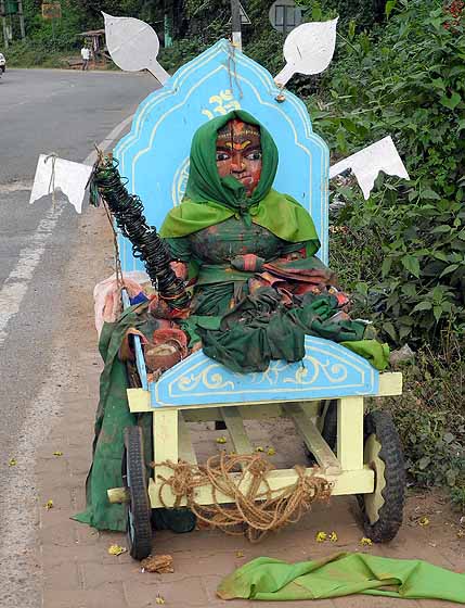 Wooden sculpture of goddess Yellamma with lots of green bangles and green saree at a roadside in Karnataka