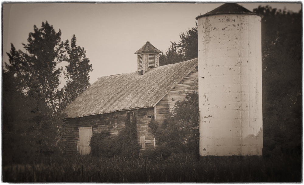 An Old Barn With a Concrete Silo