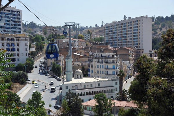 The aerial tram passes low over the minaret of a mosque