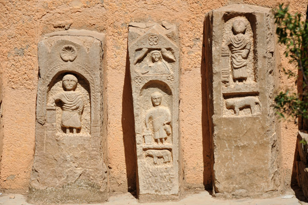 Ancient Roman tombstone propped up against the wall of the Timgad Museum