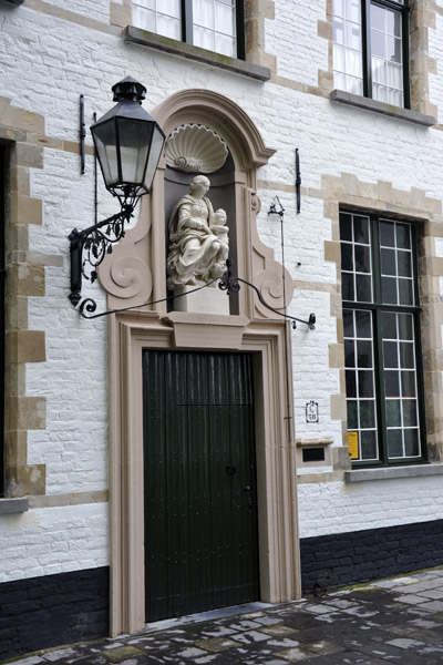 Doorway in the Begijnhof of Bruges with a statue of St Mary